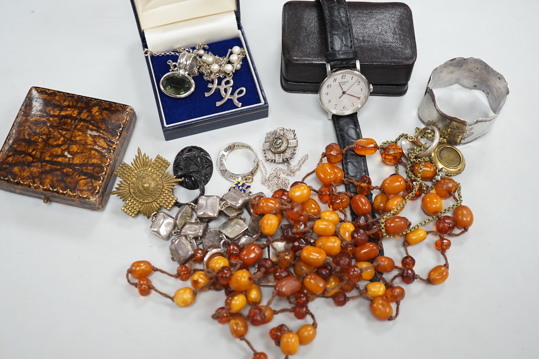 A small collection of costume jewellery, including silver pendants, amber necklace etc, together with a silver napkin ring.